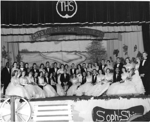 Black and white yearbook photo of a group of high school students in formal wear