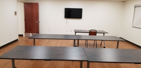 Smaller meeting room with tables and chairs.  TV access for presentations. 