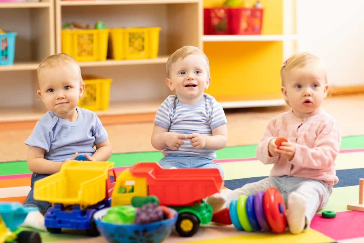 Three toddlers playing with toys.